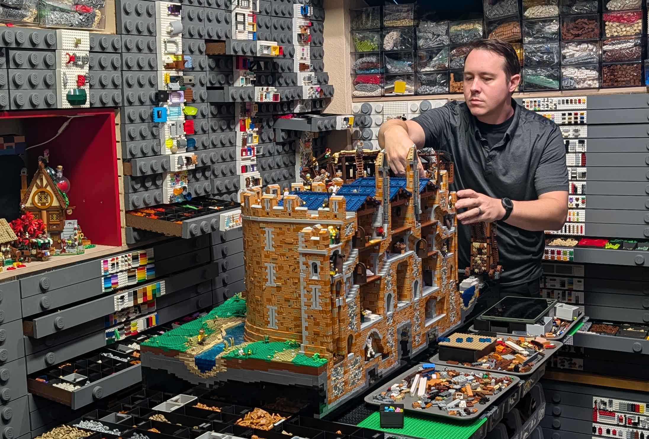 Dustin Lester working on a large LEGO® castle inside his organized building workshop